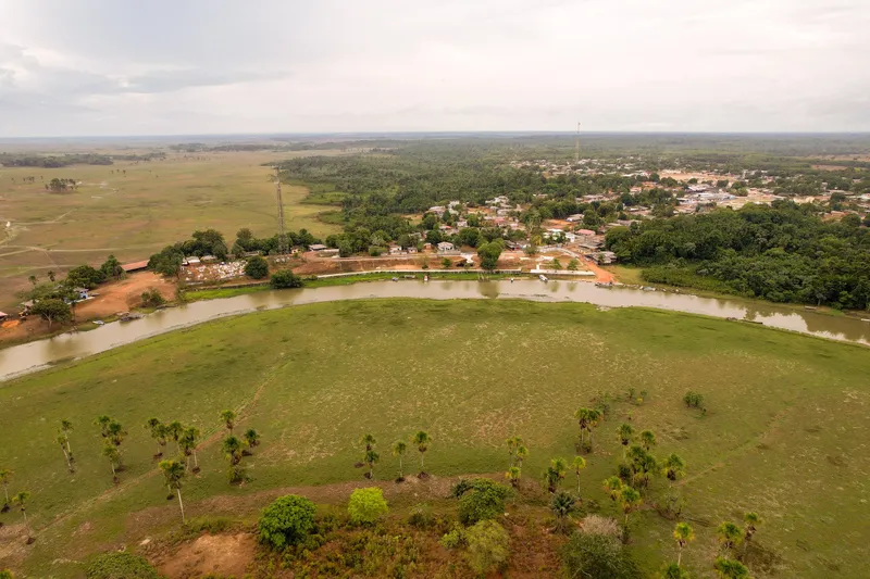 Vista aérea ampla de Itaubal do Piririm: cidade junto ao rio sinuoso, campos alagáveis e palmeiras