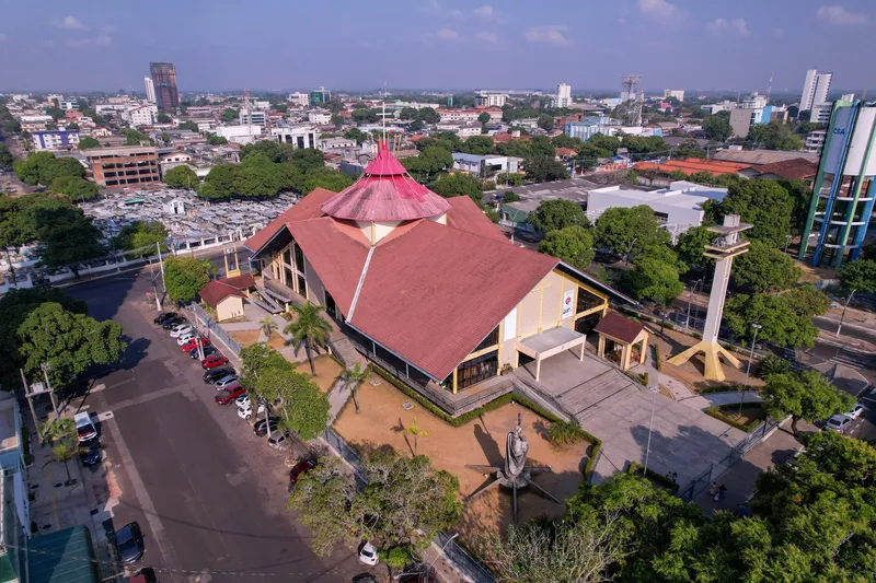 Vista aérea amplia de la Catedral de São José de Macapá y su entorno urbano, con edificios y árboles bajo cielo despejado.