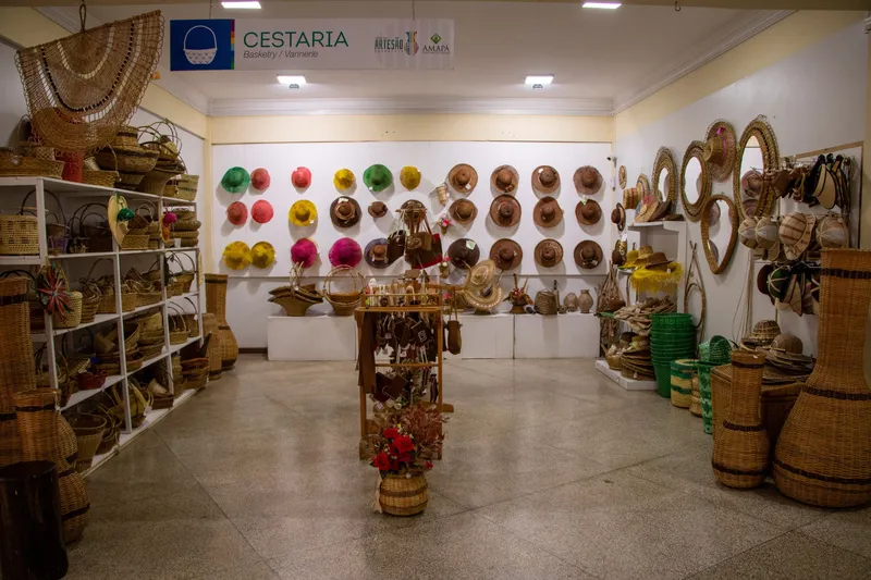 Basketry room at Casa do Artesão with colorful straw hats on the wall, baskets and woven vases.