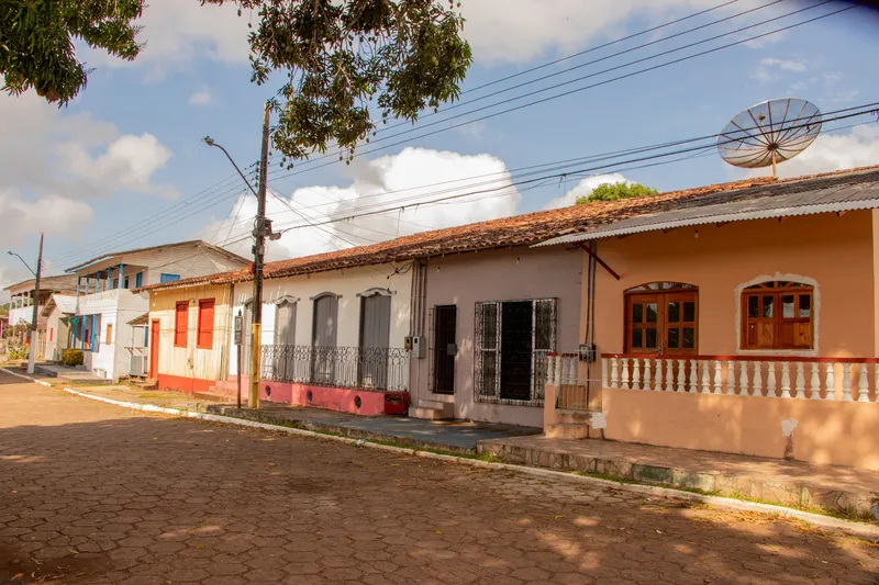 Casario antigo de Mazagão Velho em perspectiva, com telhados de cerâmica, portas em arco, grades e varanda com balaustrada.