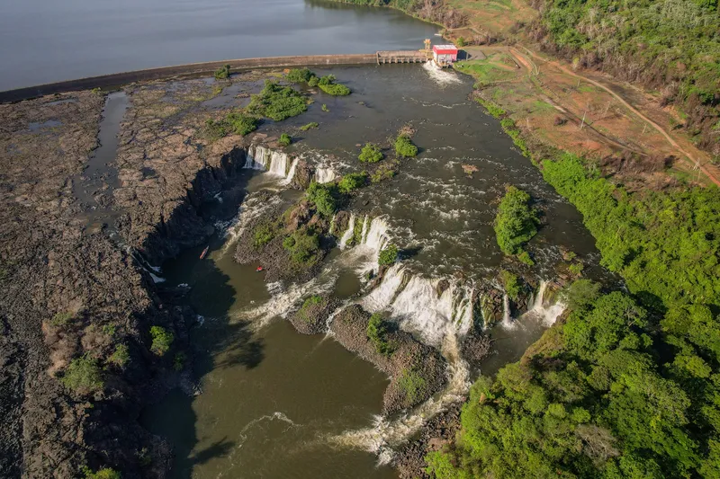 Vista aérea alta de la Cachoeira de Santo Antônio: caídas entre losas de roca, islotes de selva y el río represado