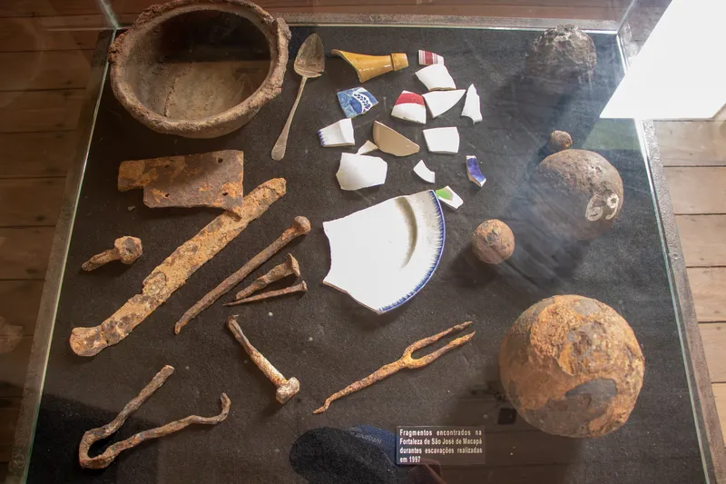 Vitrina con fragmentos de loza, cubiertos, piezas de hierro oxidado y balas de cañón hallados en excavaciones en la Fortaleza de São José de Macapá.