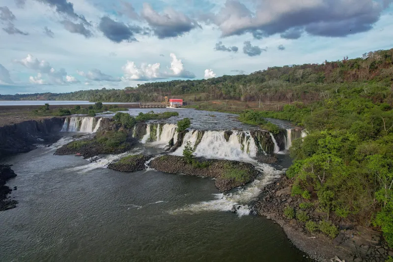 Vista aérea de la Cachoeira de Santo Antônio: varias caídas anchas en el río, orilla con selva y cielo nublado