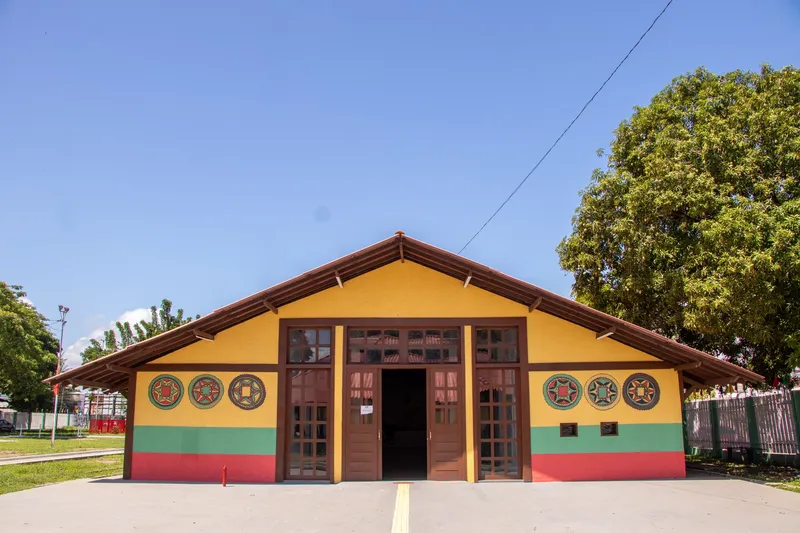 Fachada frontal de pavilhão do Centro de Cultura Negra do Amapá, pintada de amarelo, verde e vermelho, com mandalas.