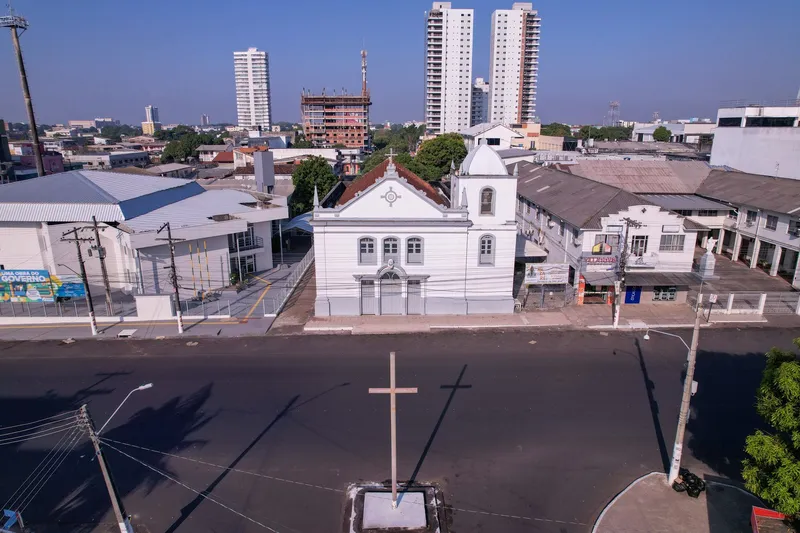 Vista aérea frontal da Igreja Matriz de São José de Macapá, com a cruz de madeira na praça em frente e a cidade ao fundo.