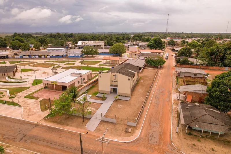 Vista aérea da Igreja São Benedito ao lado da praça, com ruas de terra e casas de Itaubal ao redor