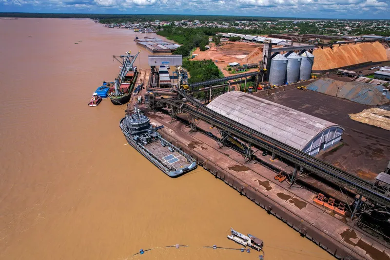 Vista aérea del muelle de las Docas de Santana con buque gris atracado, almacén abovedado, silos y cintas de carga.