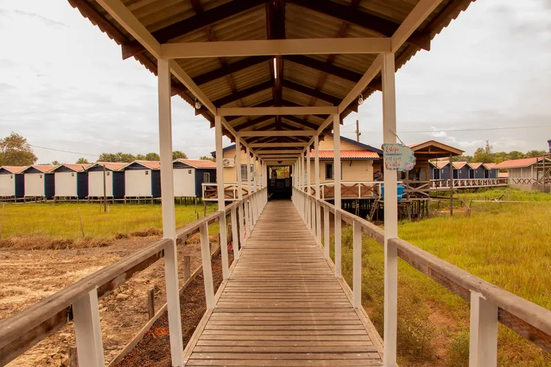 Covered wooden walkway at Paraíso da Sereia, with chalets on stilts on both sides