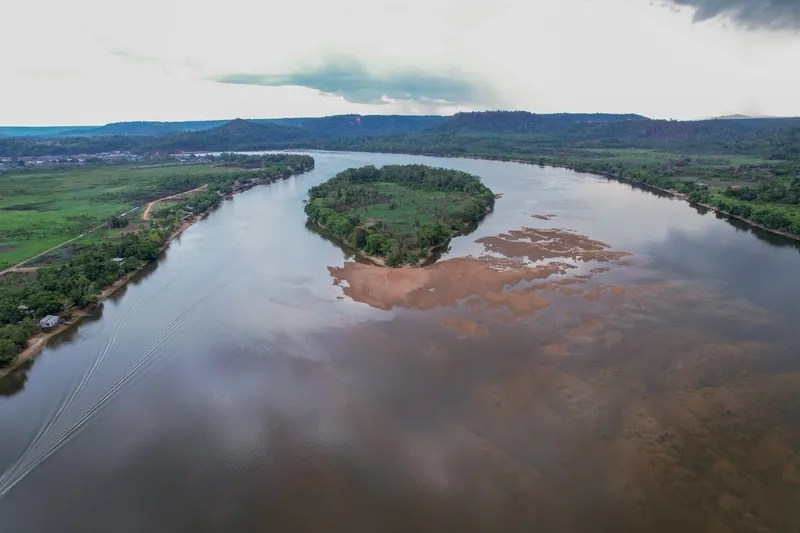 Aerial view of the river with a wooded island and the sandbanks of Praia da Samaúma, hills behind
